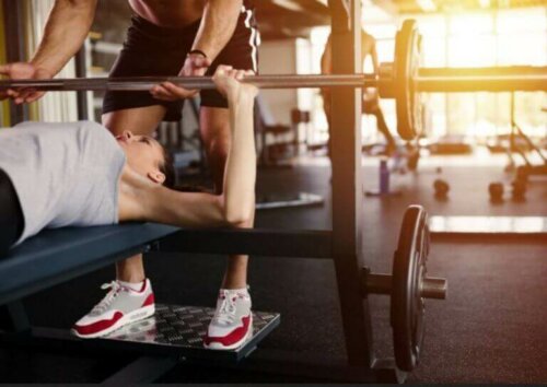 Spor salonunda ağırsiklet antrenmanı yapan çift