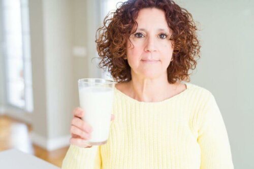 Yaşlı kadın kemiklerini güçlendirmek için süt içiyor.
