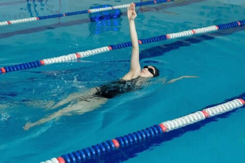 Bir kadın havuzda sırtüstü yüzüyor