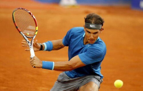 Bir tenis topuna vuran Rafael Nadal.