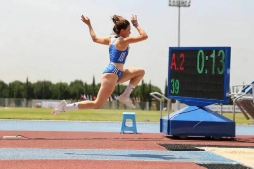 Uzun atlama etkinliklerinden birinde yarışmakta olan bir kadın sporcu.