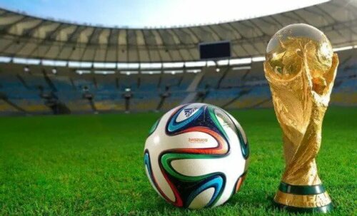 FIFA kupası ve yanında duran bir futbol topu.
