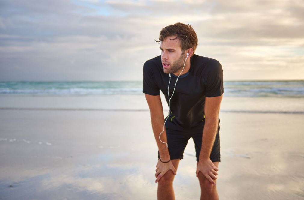 Man resting while running on the beach