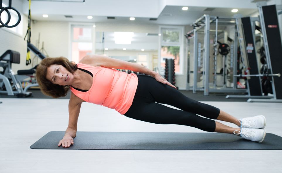 Woman doing side plank at the gym