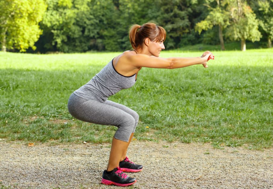 Woman doing squats outdoors