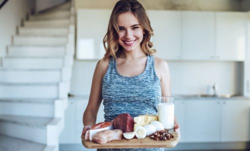 woman holding board with protein sources