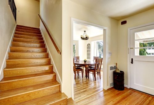 stairwell and dining area with wood floors