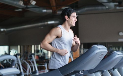 mand der løber på løbebånd i fitnesscenter