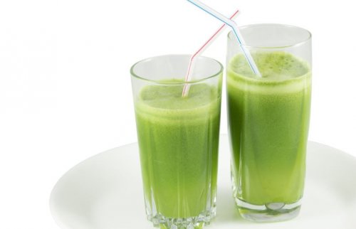two glasses of green smoothies with straws