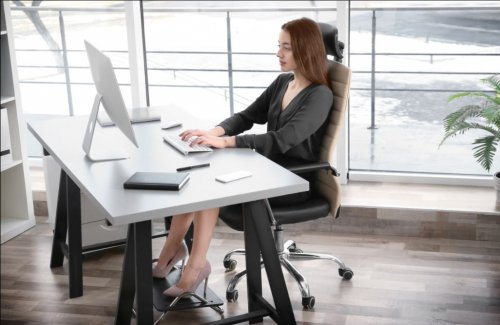 woman working at desk with ergonomic equipment