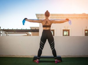 Woman doing resistance band exercise on roof