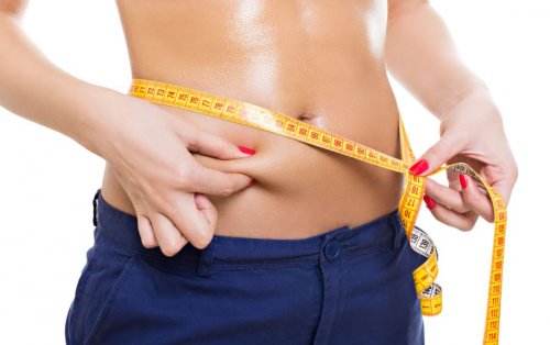 woman measuring waist and pinching fat fat burners