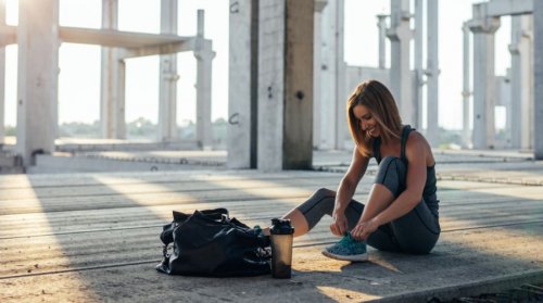 woman smiling tying her shoes exercise regularly