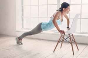 Woman doing exercise with chair.