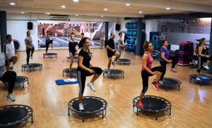 People doing power jump at the gym.