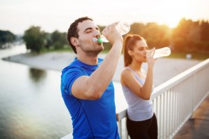 Couple drinking water after working out.