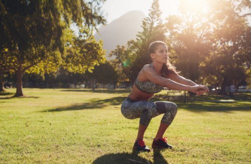 woman squatting outside in workout clothes
