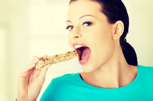 woman with cereal bar and mouth open
