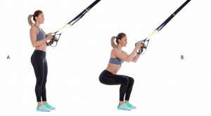 Woman doing squats with TRX.