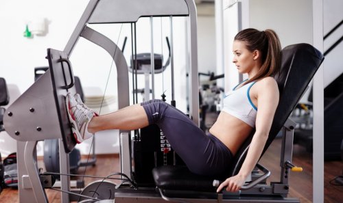 woman at leg press machine at gym toning and bulking up