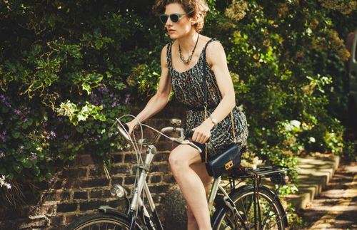woman in dress and shades riding a bike cellulite and exercises