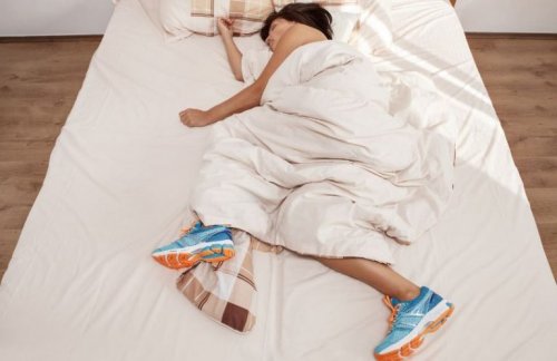 woman sleeping in bed with running shoes