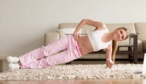 Woman doing a side plank to reduce belly fat.