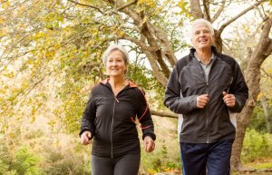 Way to age better: A couple running in the woods.