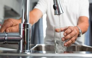 Men pouring water from the faucet.