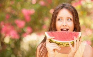 Woman eating watermelon during summer.