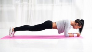Girl doing a plank to reduce belly fat.