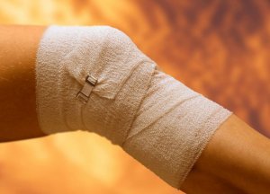 Knee wrapped in a bandage.