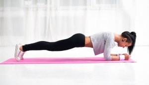 Woman doing plank and back exercises.