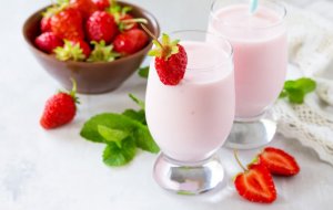 Two cups of yogurt with strawberries for breakfast.