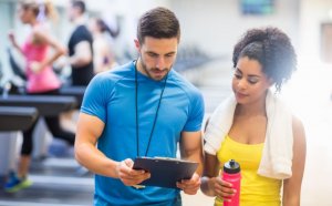 Woman and personal trainer preparing exercise program.