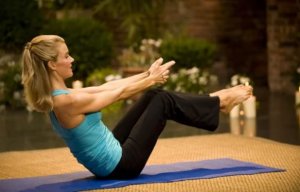 Woman doing the boat yoga pose.