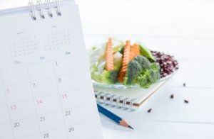 A calendar to plan a healthy diet and a plate with healthy food.