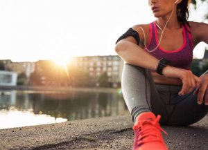 Woman resting on the sidewalk after running.