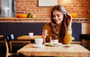 Woman eating a dessert in a coffee shop.