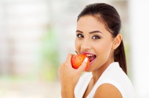 Woman eating an apple as part of the macrobiotic diet.