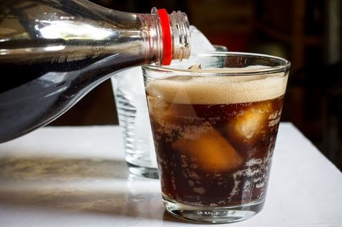 cola der hældes over i glas med isterninger