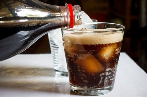 cola der hældes over i glas med isterninger