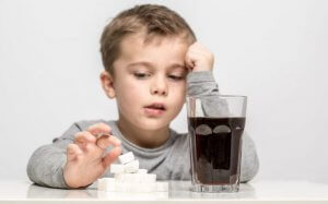 Boy comparing soda with sugar cubes