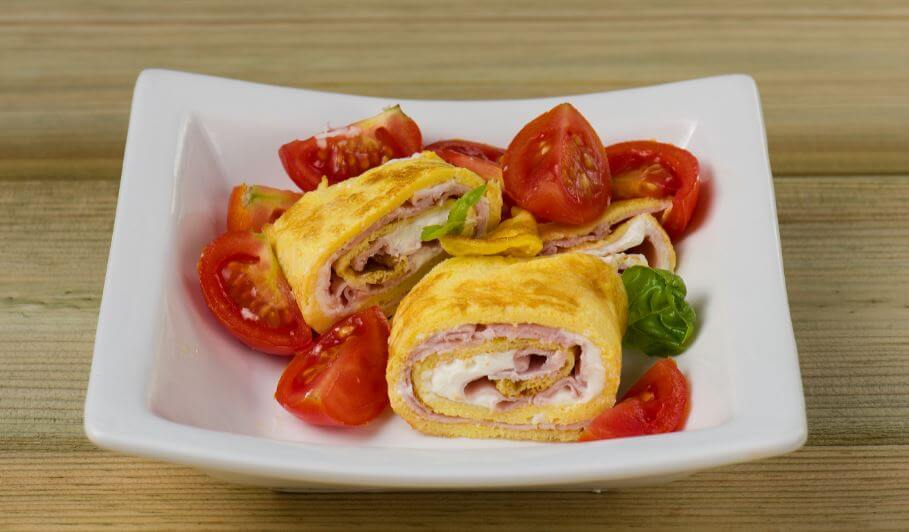 Ham and cheese rolled potato omelette with tomato garnish