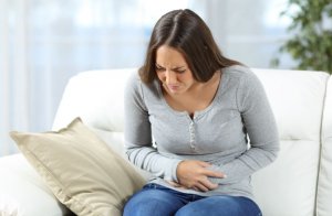Woman with stomachache for eating gluten-free foods.