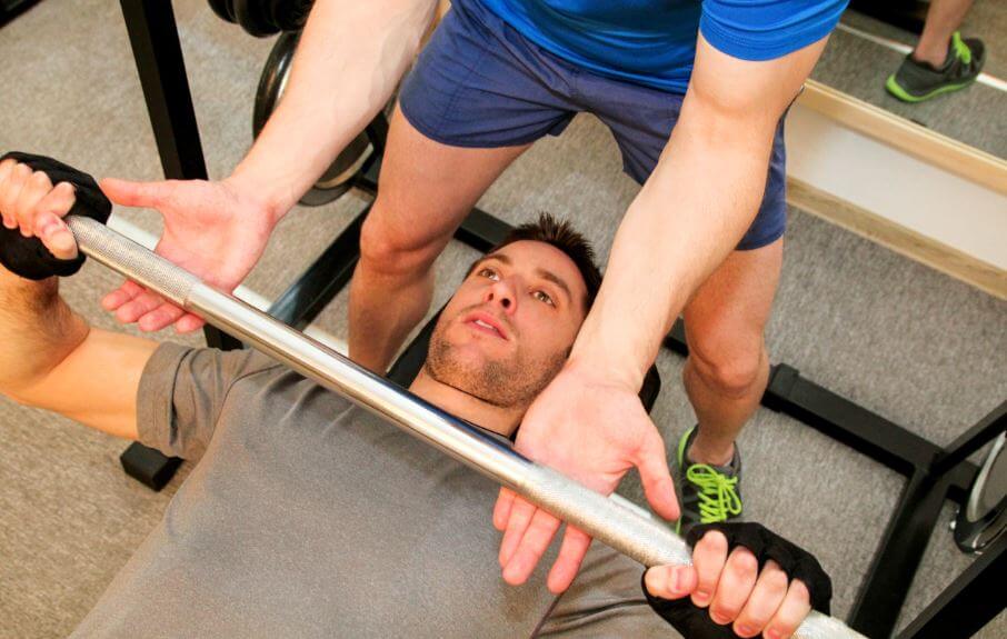 Man and trainer bench press