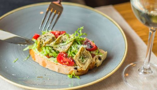 Toast with artichoke tomatoes and arugula