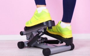 Woman using a mini stair climber machine.