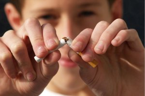 Boy breaking a cigarette to reduce stress.