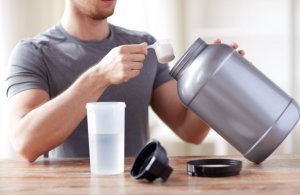 Guy taking supplements after training.